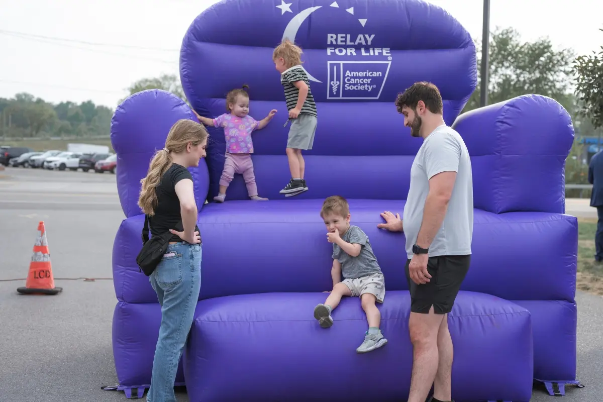 Family with young children at the American Cancer Society Relay for Life inflatable during the Drive for a Cure event at Certified AutoBrokers in Grand Island NY