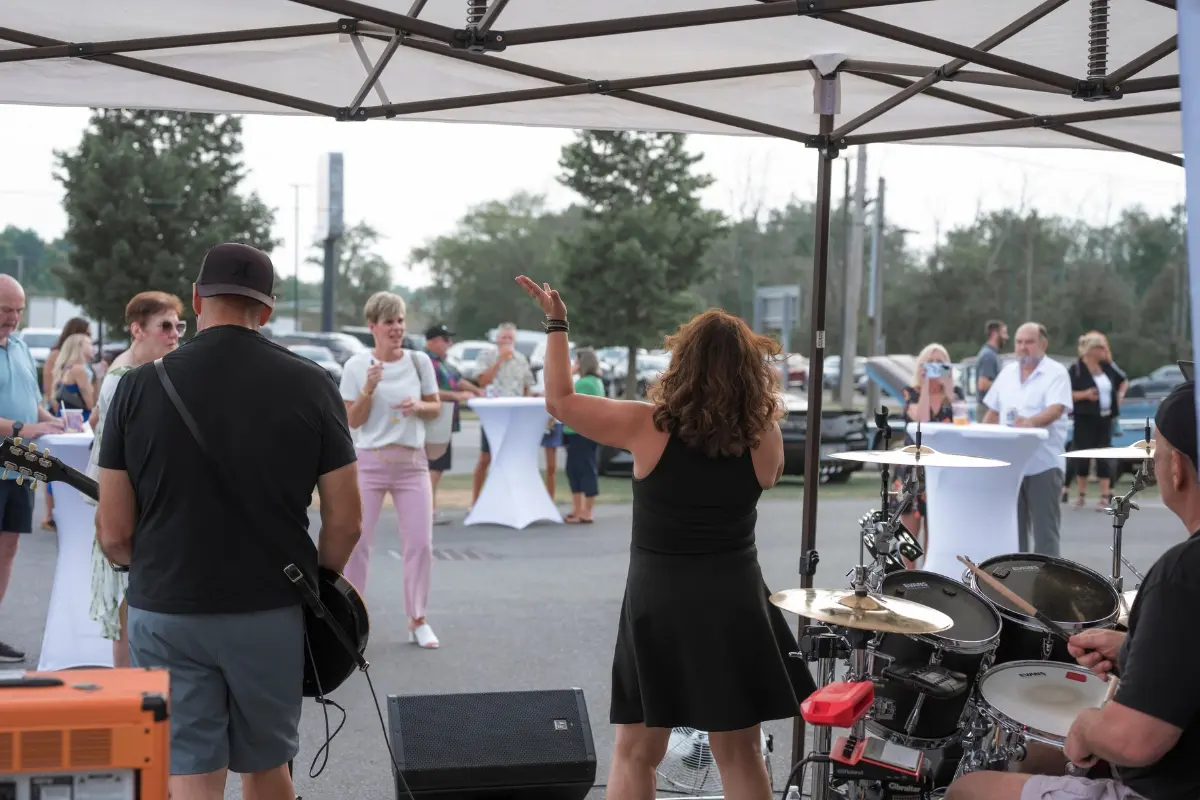 Live band performing for guests outdoors during the Drive for a Cure celebration at Certified AutoBrokers in Grand Island NY
