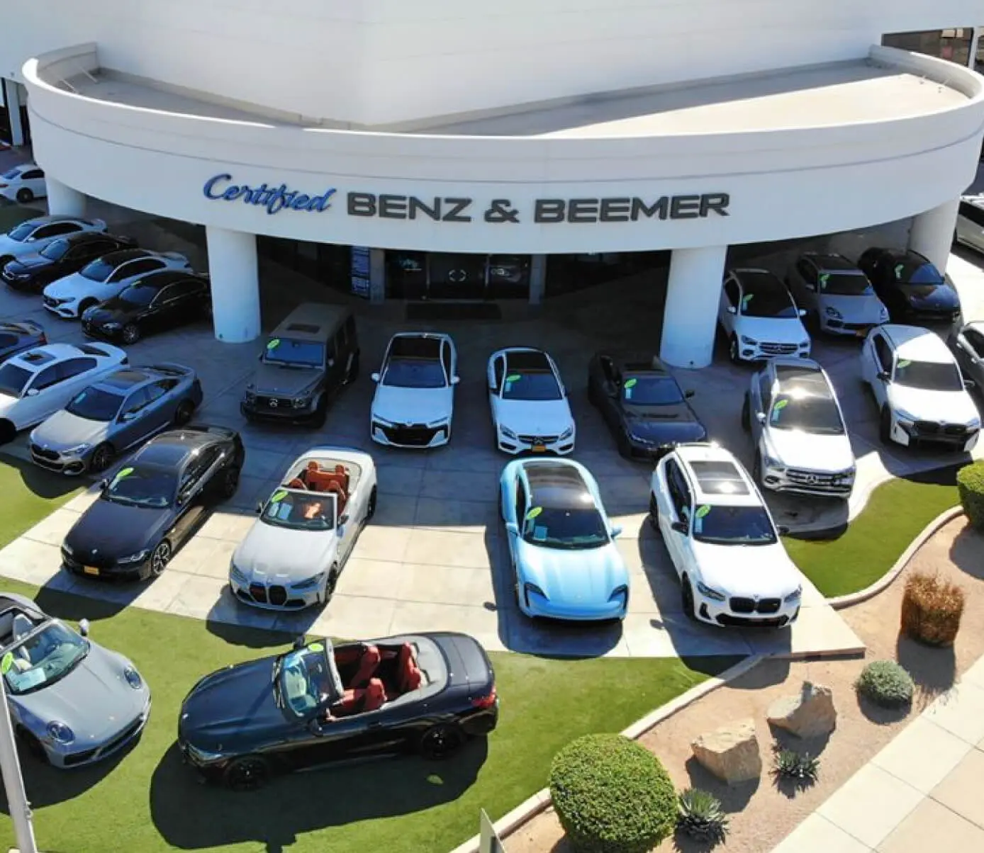 Aerial view of Certified Benz and Beemer dealership with several used Mercedes cars parked out front.
