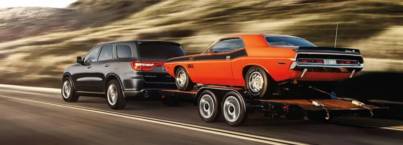 A durango pulling a trailer on the road.