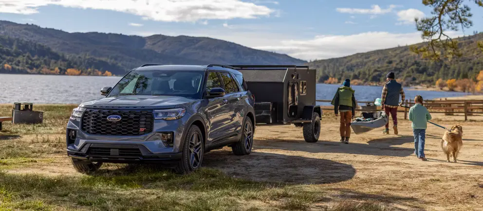 A ford explorer sitting parked with a trailer.