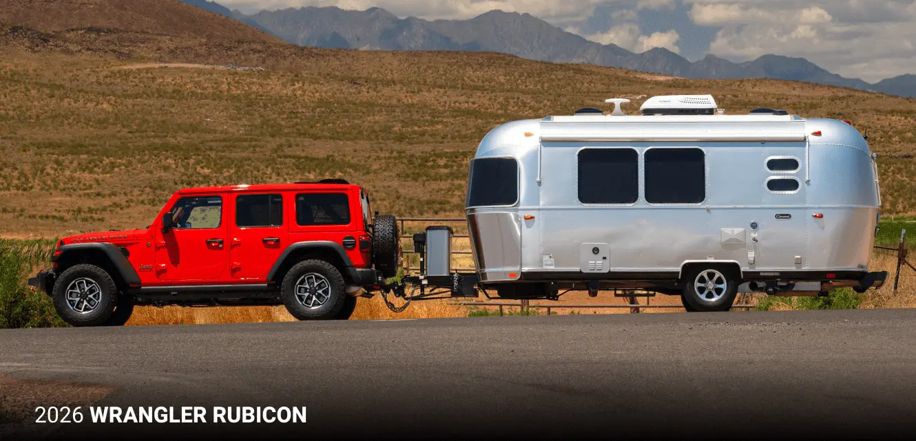 A red wrangler pulling a mobile home.