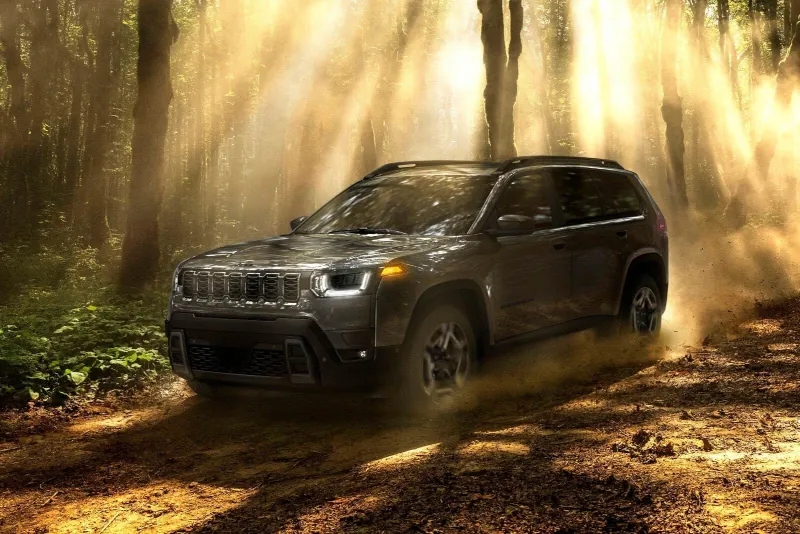 A blue suv sitting parked off-road.