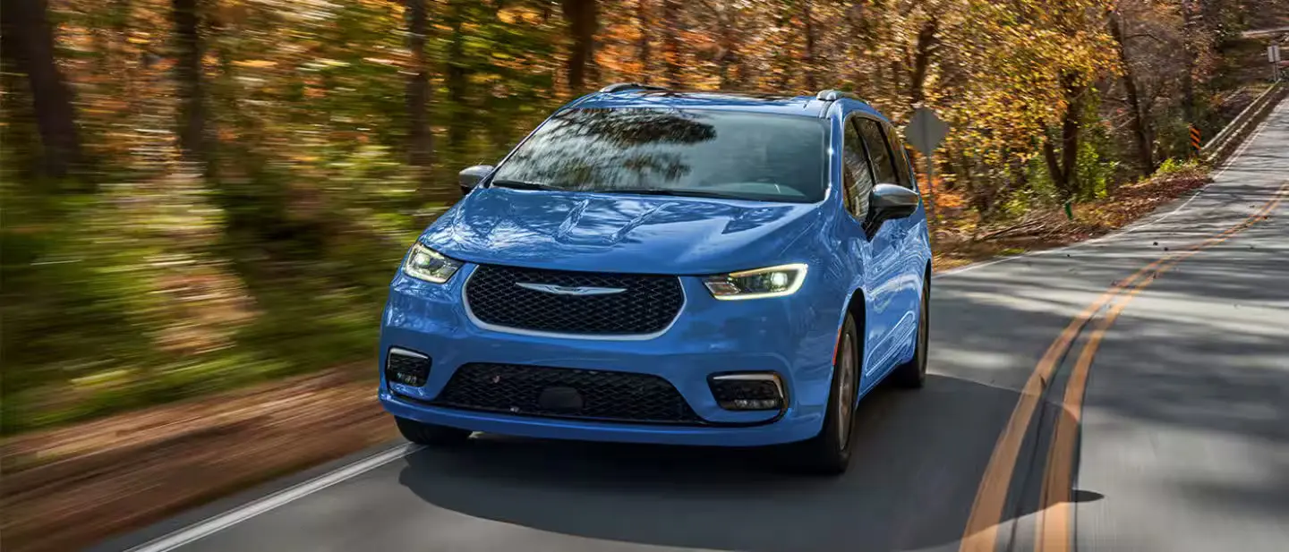 A blue van driving on the road.
