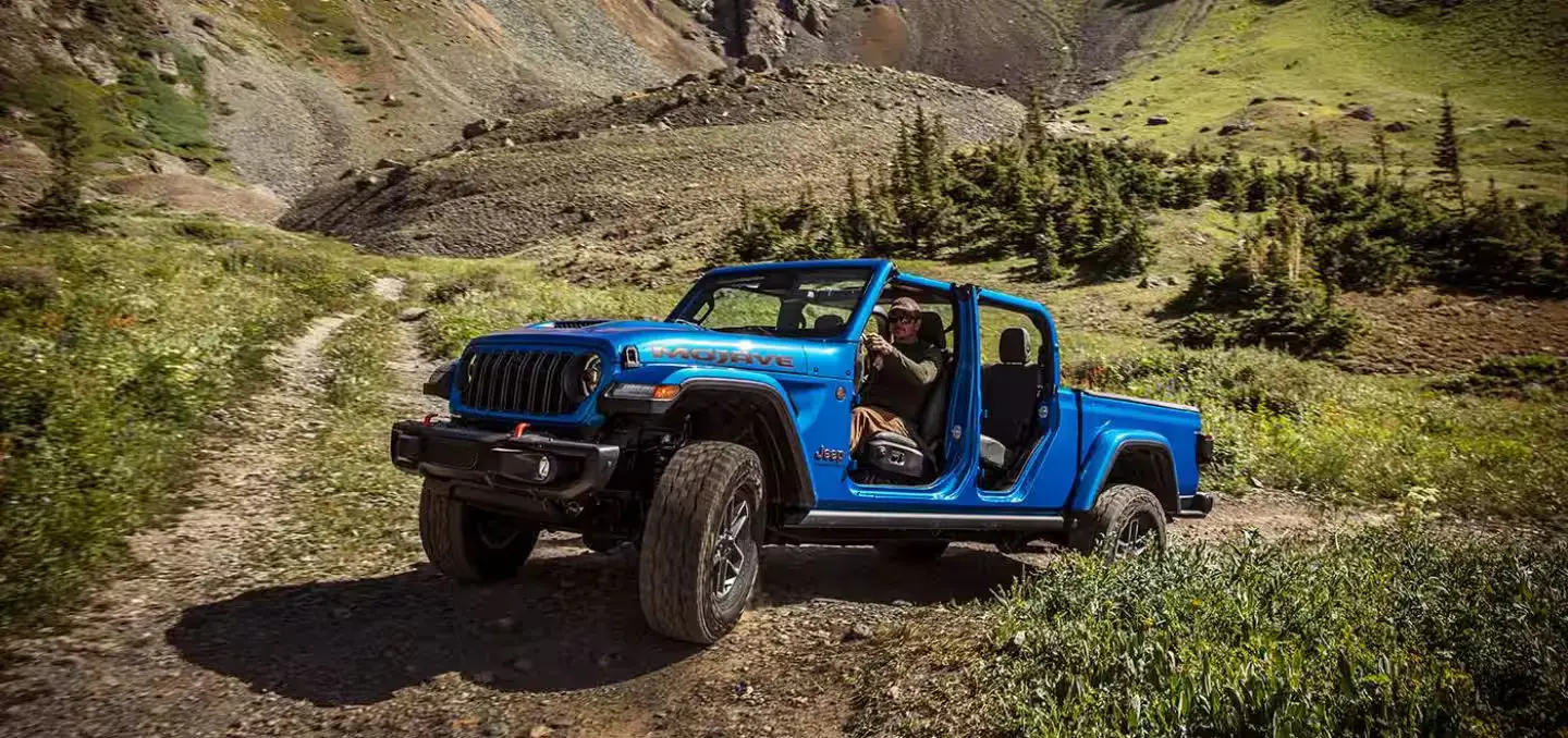 A blue jeep driving off-road.