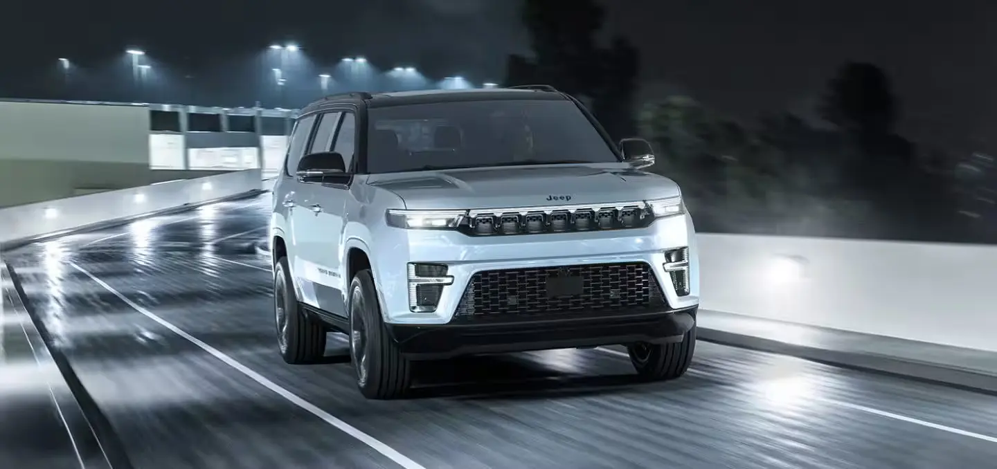 A white jeep suv driving on the road.