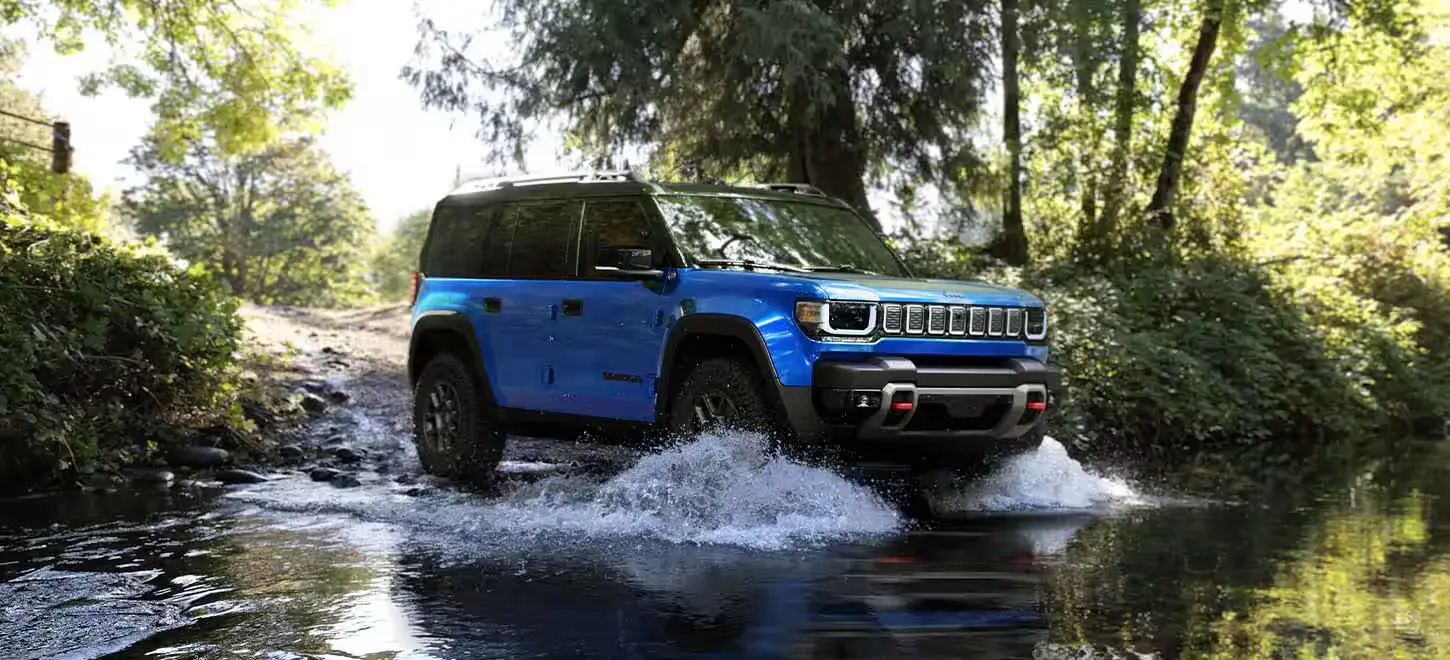 A blue jeep recon driving through some water.