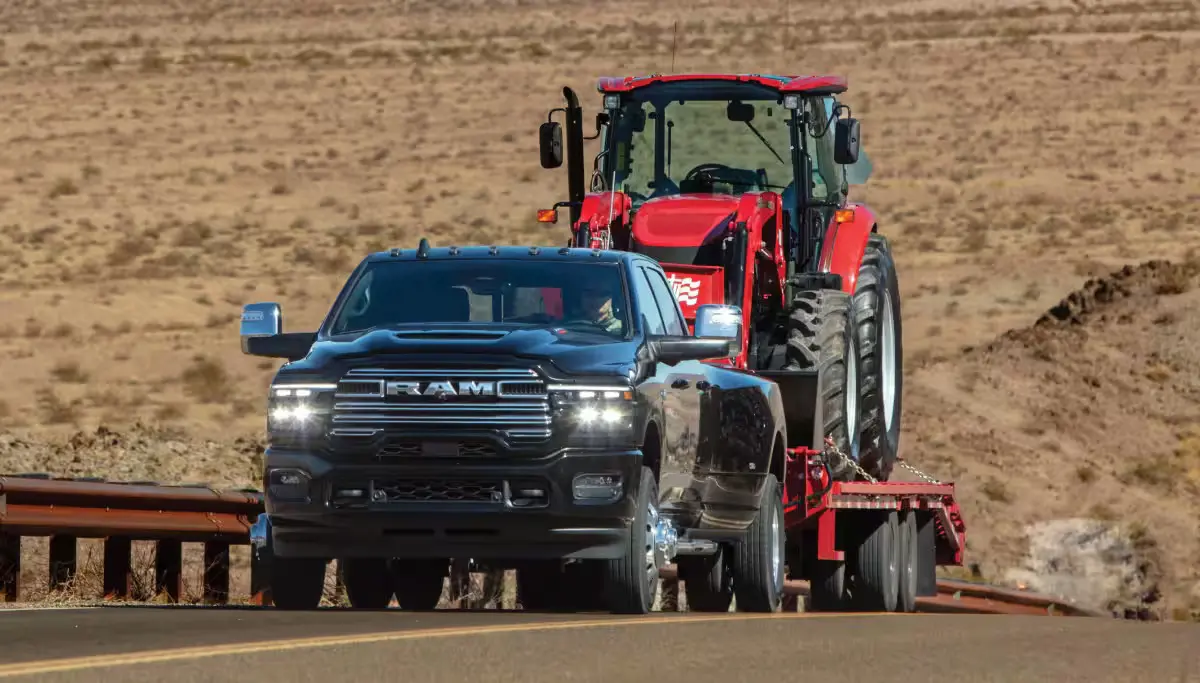 A ram 3500 pulling a trailer witha tractor on it.