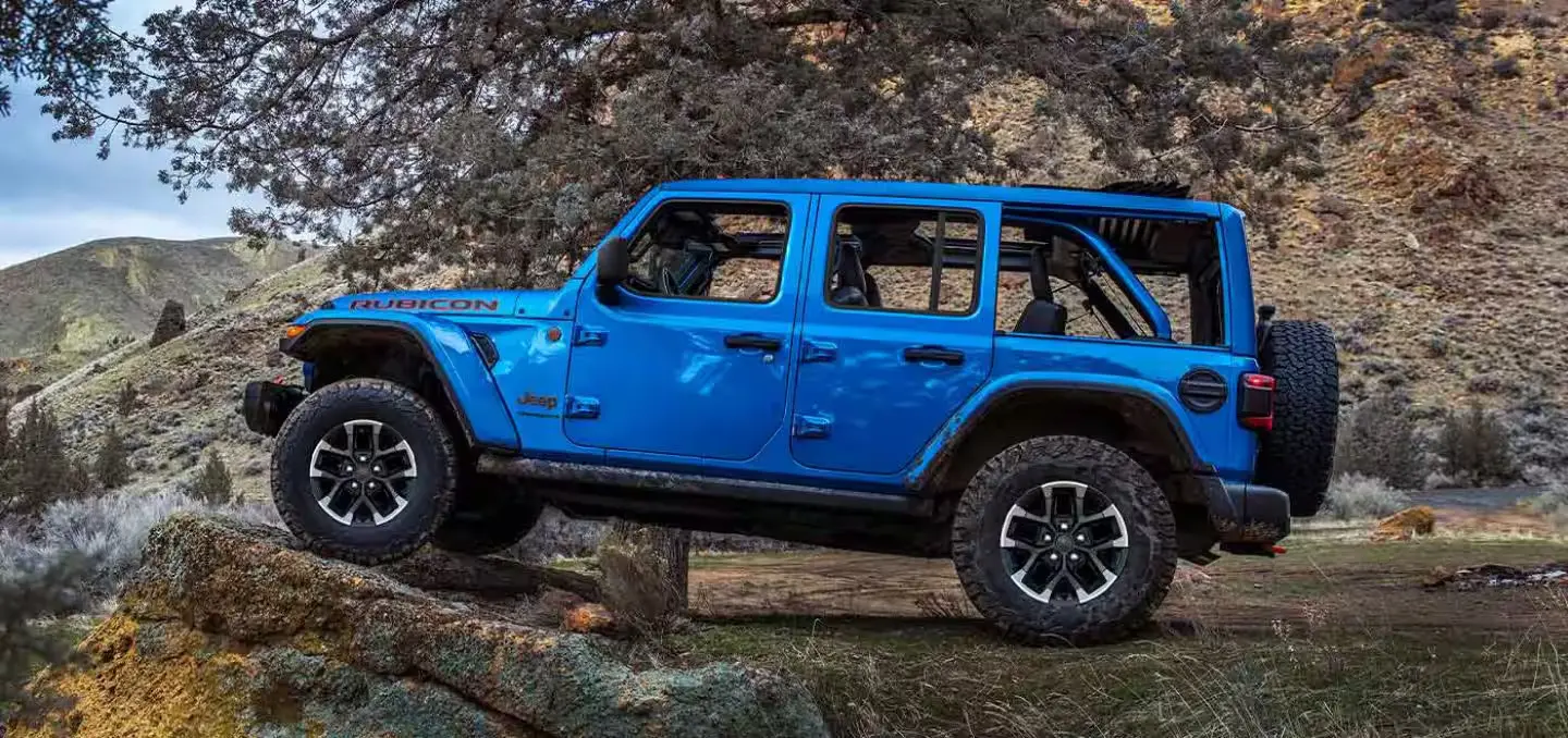 A blue jeep sitting parked off-road.