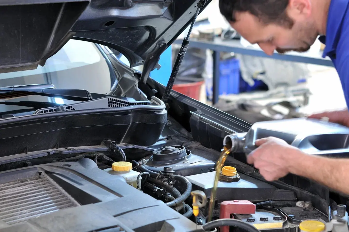 A man changing the oil in a car.