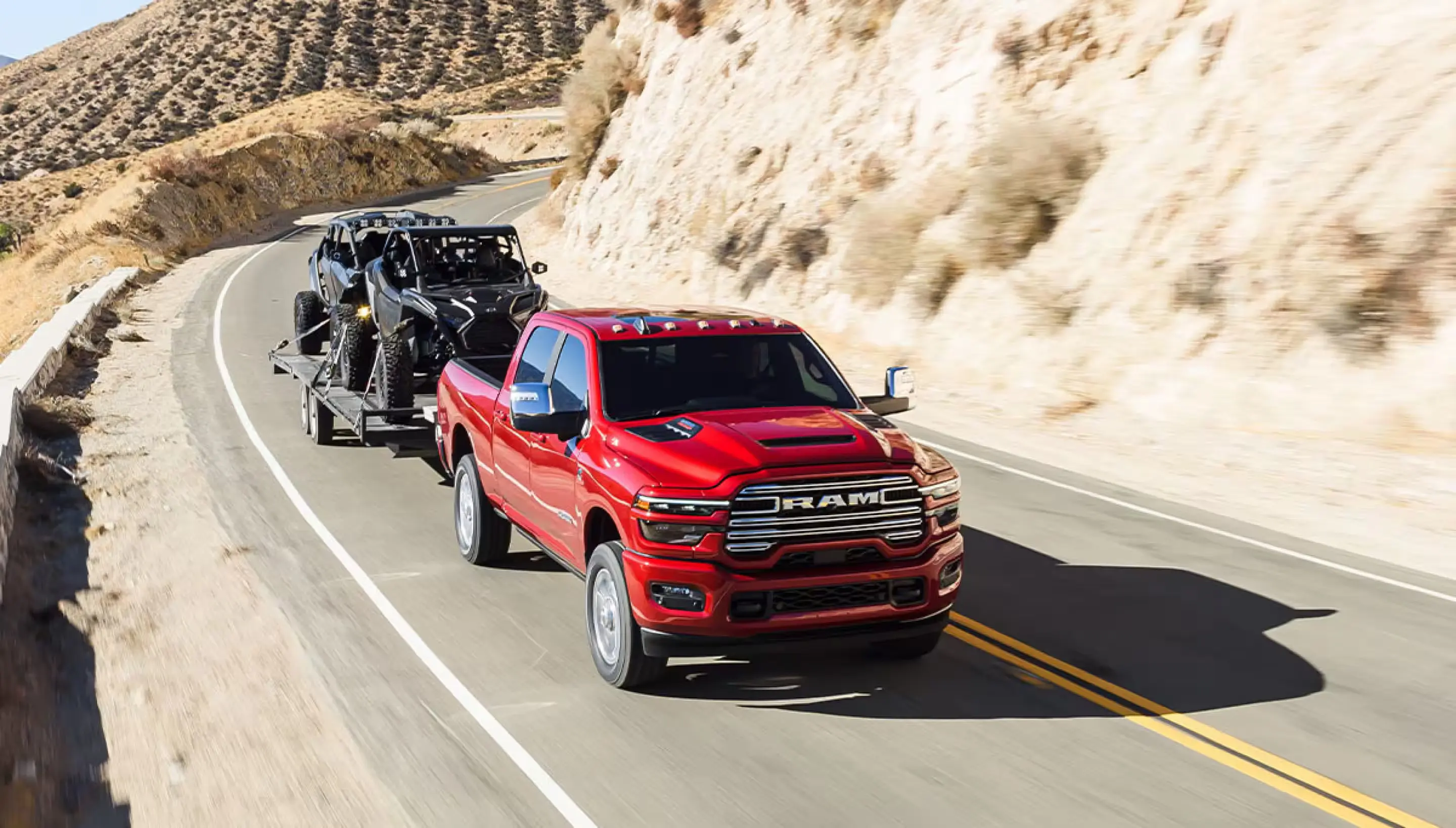A red truck pulling a trailer on the road.