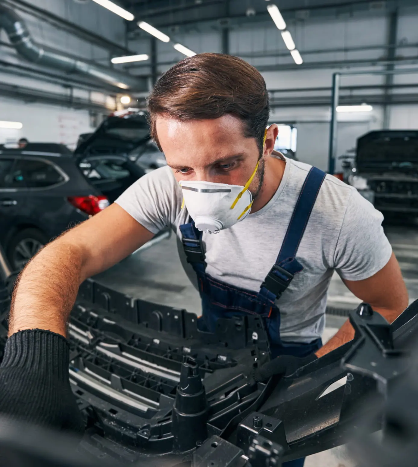Automotive technician working on a vehicle in a service center.