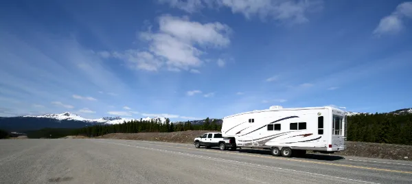 White RV being towed on open road