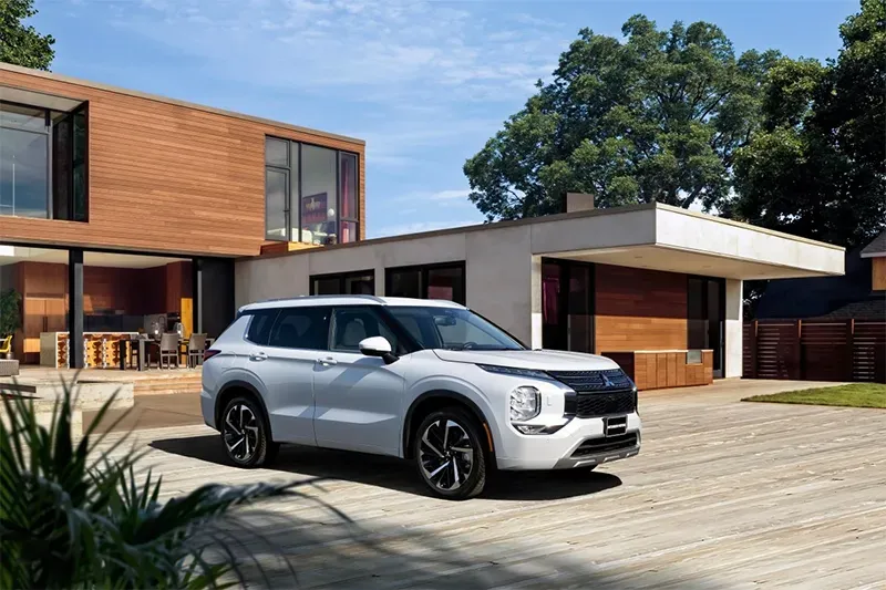 White Mitsubishi vehicle parked in front of driveway