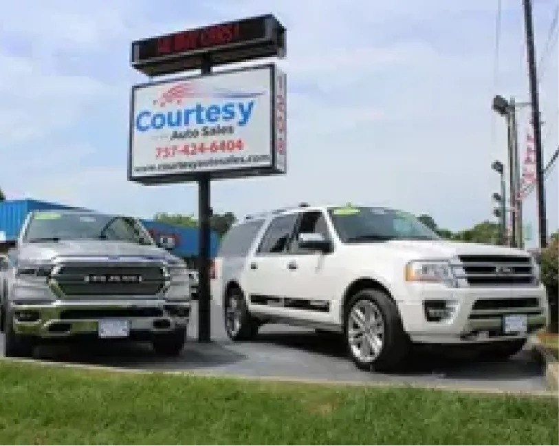 Courtesy Auto Sales sign with used vehicles parked outside the Chesapeake dealership