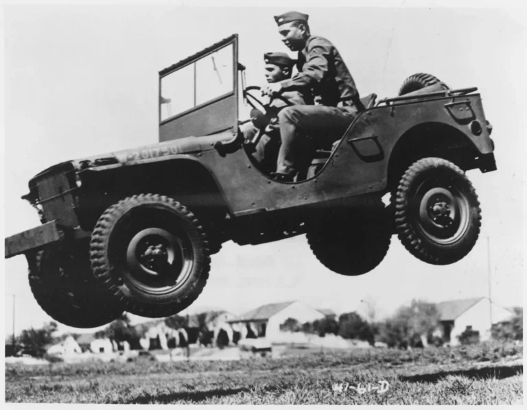 Two American GI's jumping a WWII Jeep Willy