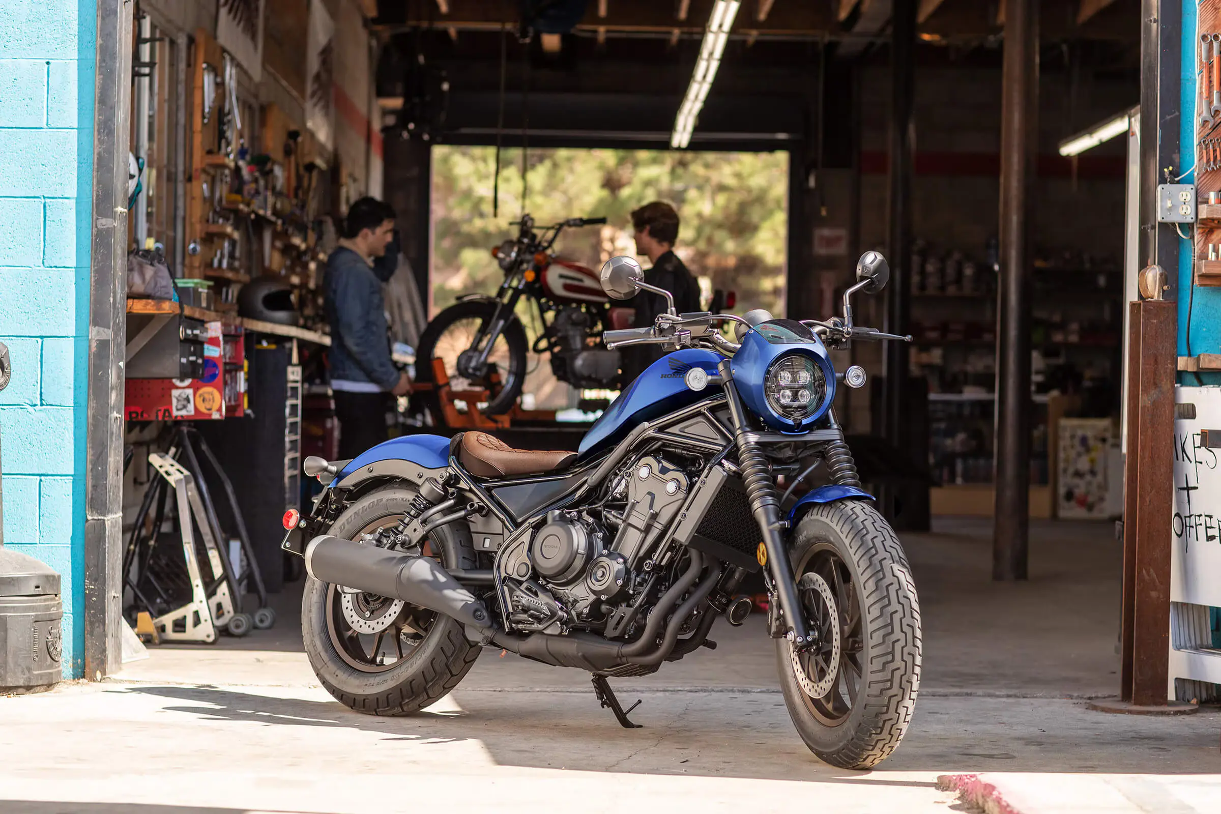 blue honda rebel 500 parked outside garage