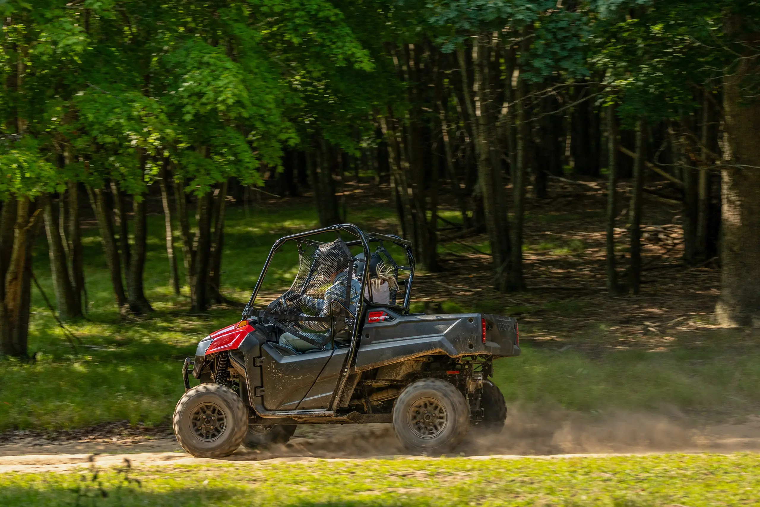two people riding in a honda pioneer 700