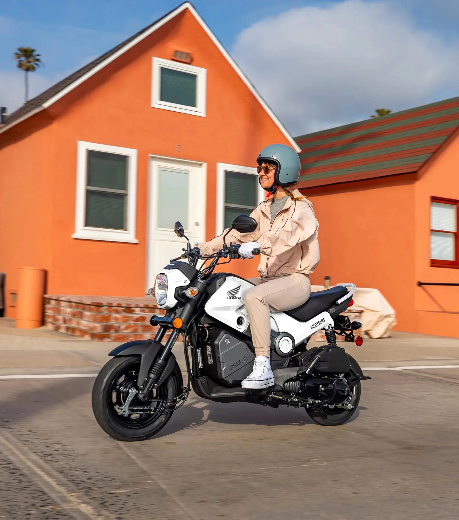 woman riding a white honda navi