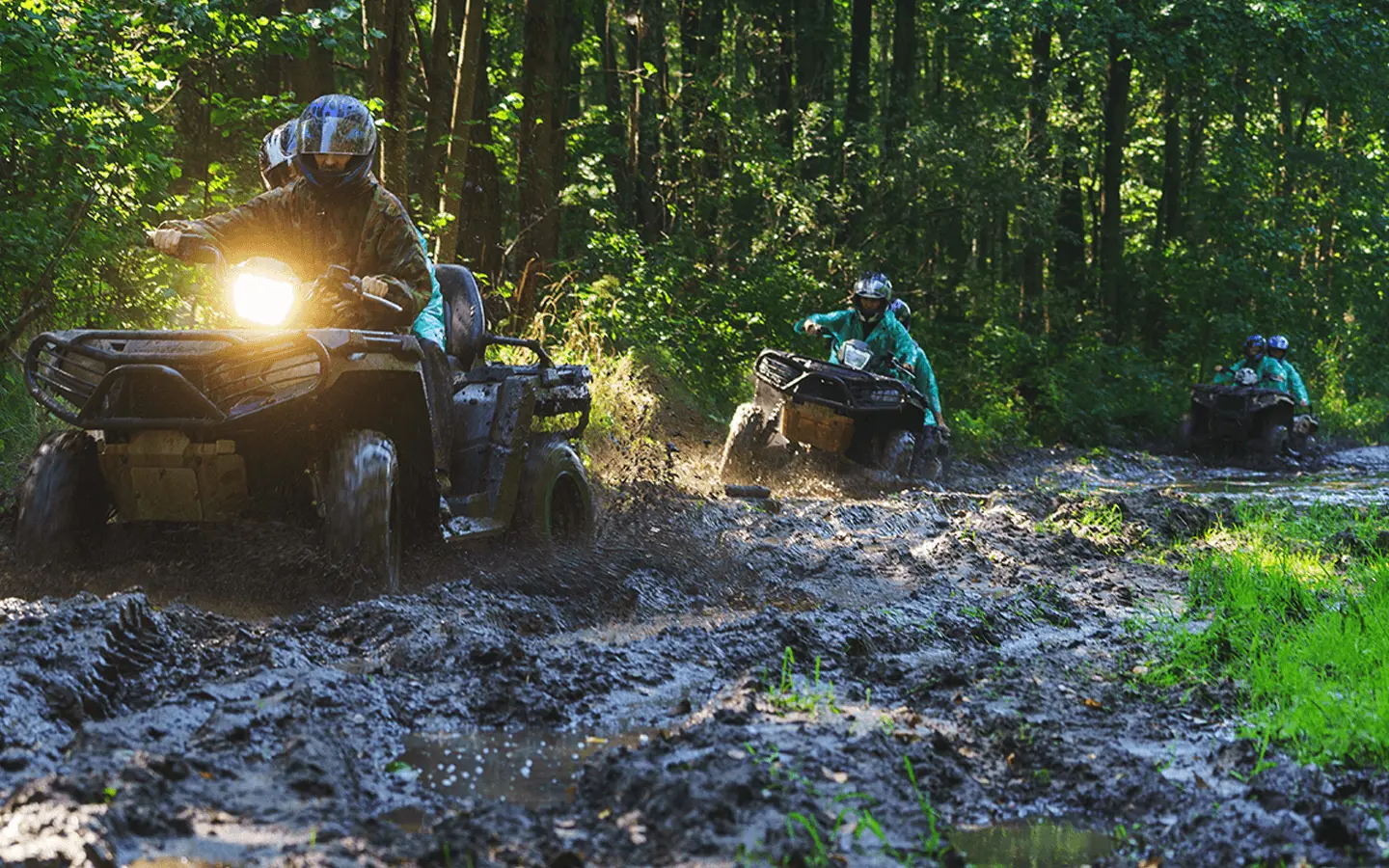 group of avt riders riding through mud