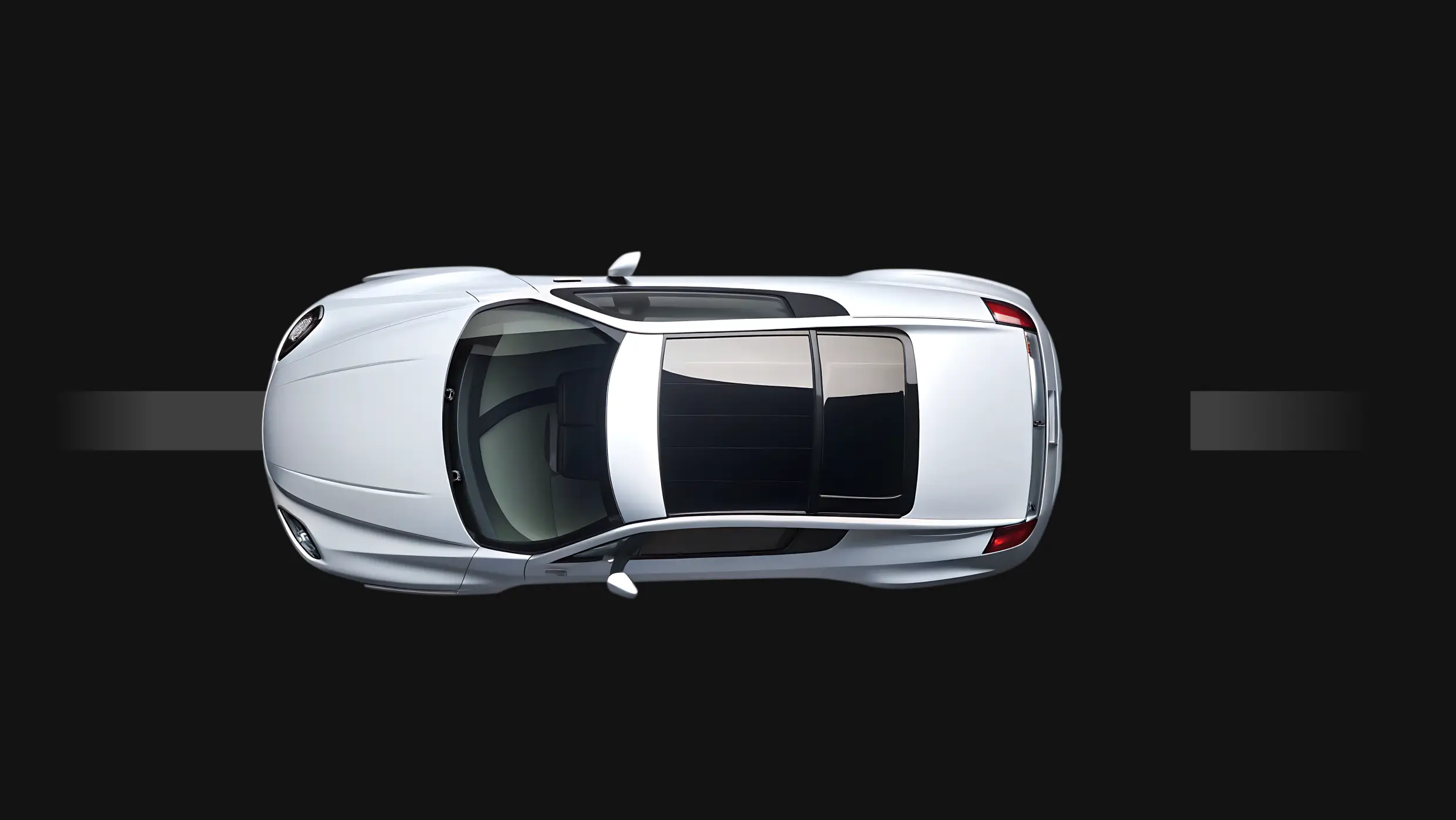 Top view of a silver vehicle driving on a dark road background.