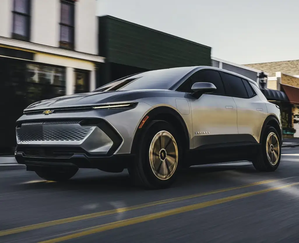 Silver Chevrolet Equinox EV driving through a city street