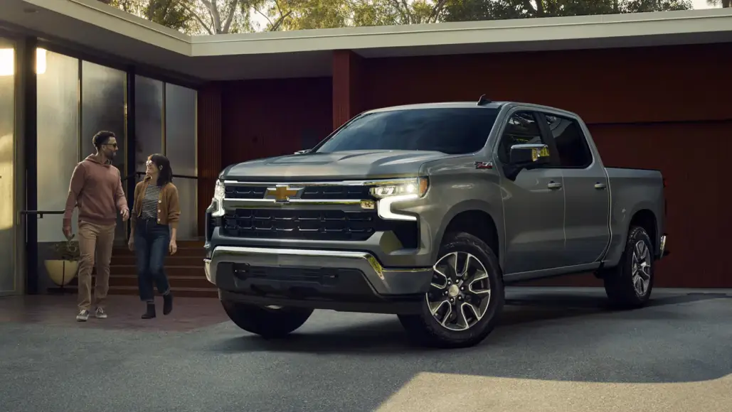 Chevrolet Silverado parked outside a home with two people walking nearby
