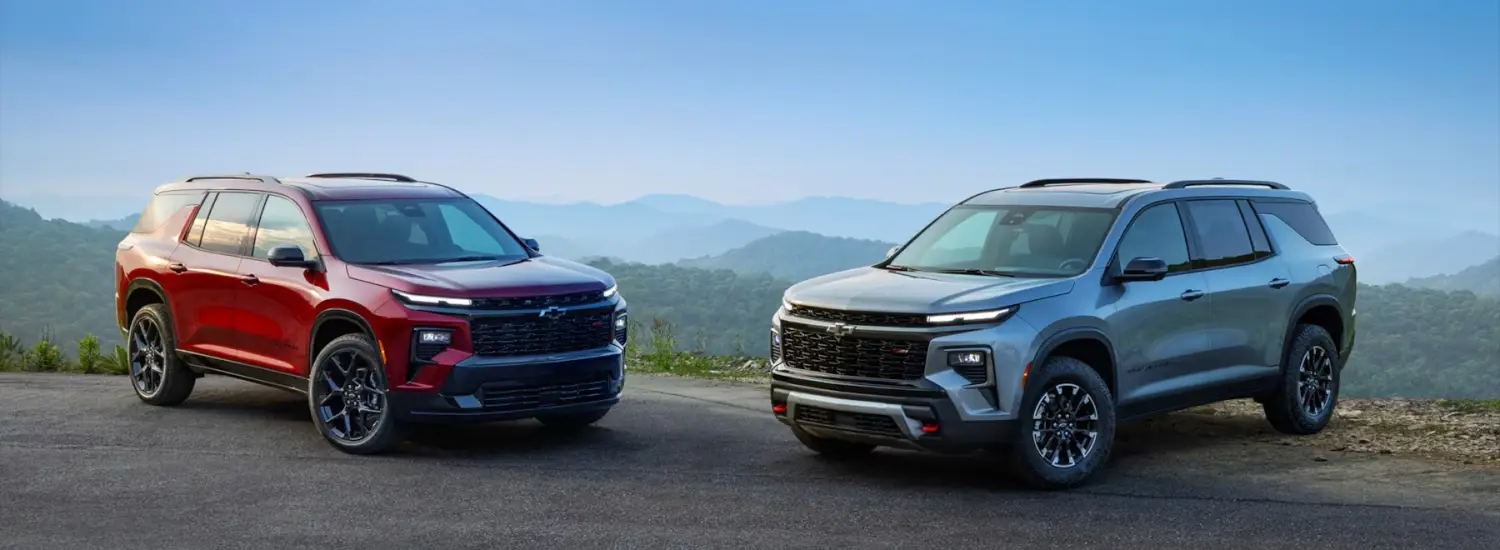 Two Chevrolet SUVs parked on a mountain overlook