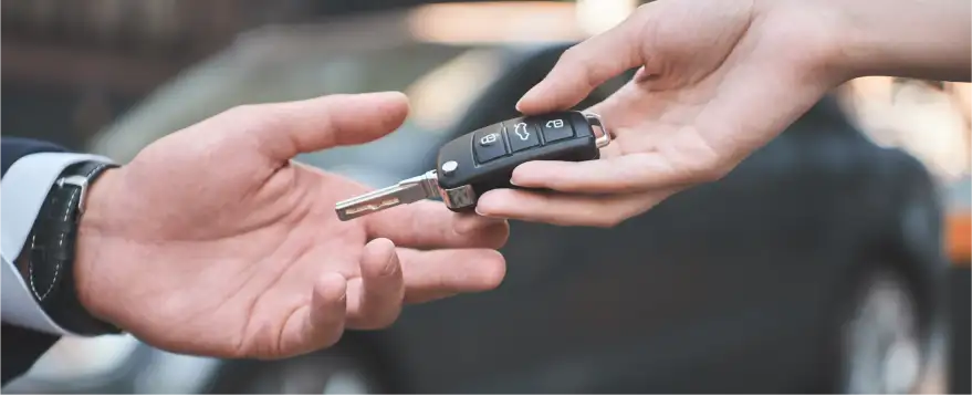 Car key being handed to a customer at Electric Car Corner