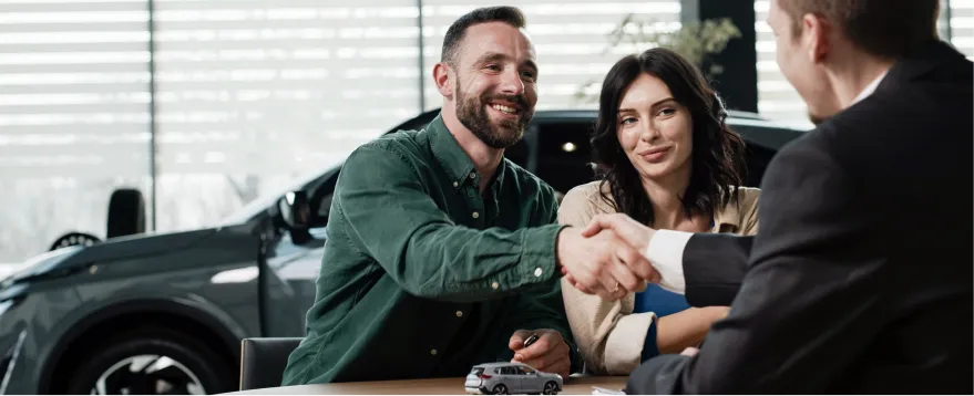 Couple discussing monthly payment options with a dealership representative