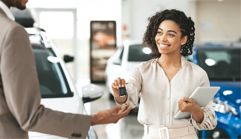 Customer receiving vehicle keys at an Emich Automotive dealership