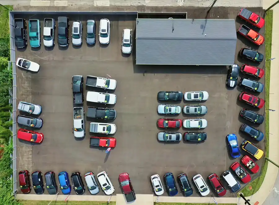 Aerial view of the Fast Lane Autos dealership lot with pre-owned vehicles arranged around the building