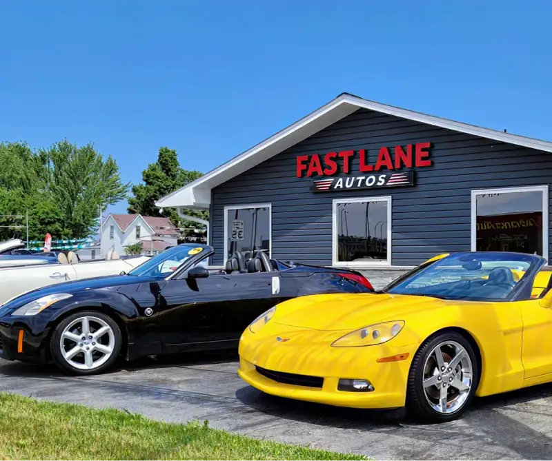 Fast Lane Autos dealership building with two sports cars parked out front