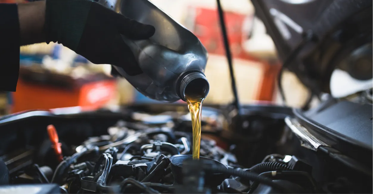 Technician pouring fresh oil during a vehicle oil change service