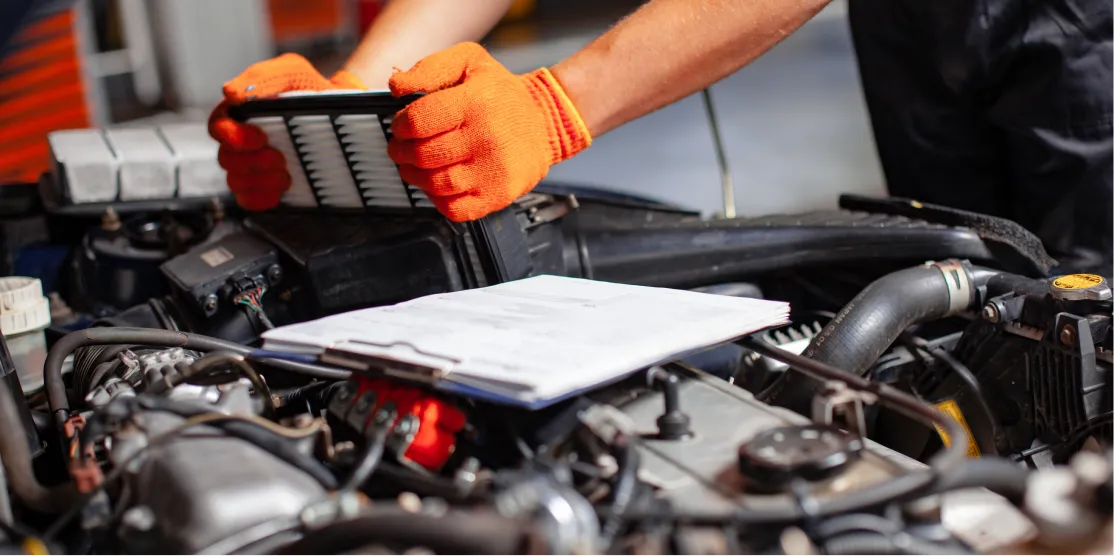 Technician replacing an engine air filter during routine maintenance
