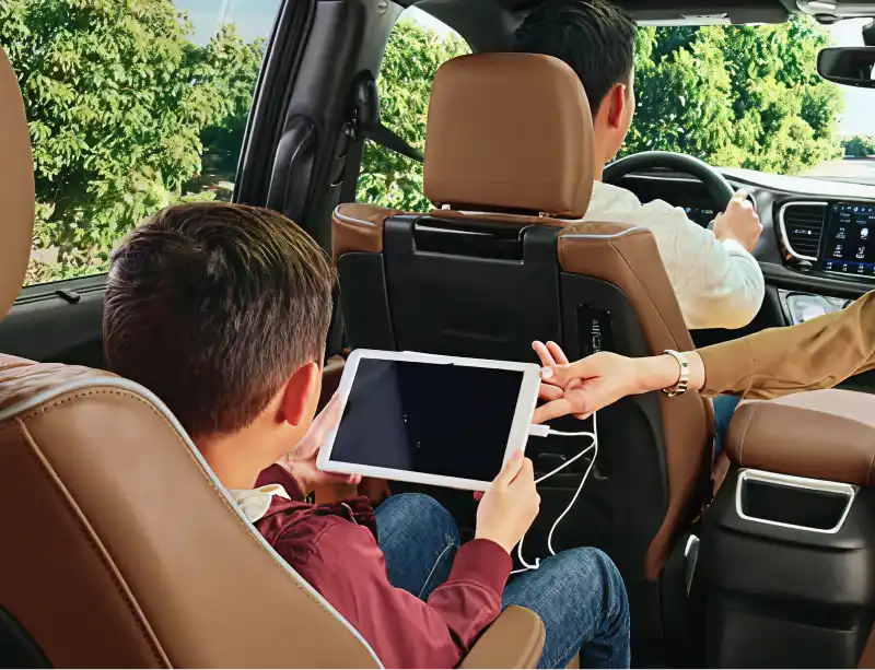 Passenger using a tablet inside a connected vehicle
