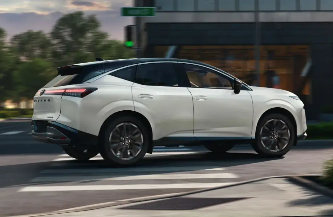 White 2025 Nissan Murano driving through a city intersection