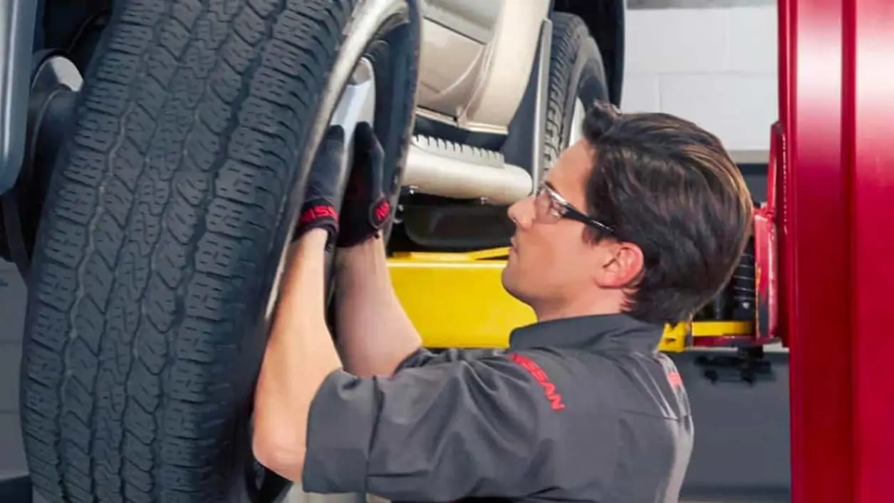 Nissan technician rotating a tire on a lift