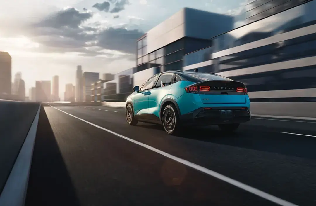Blue Nissan driving on a city highway