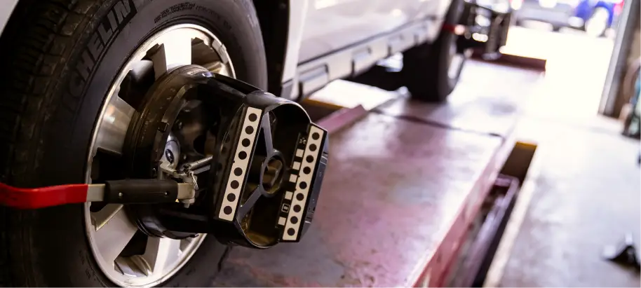 Wheel alignment service being performed on vehicle.
