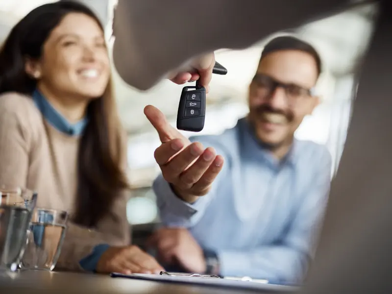 Couple receiving the key to their new vehicle