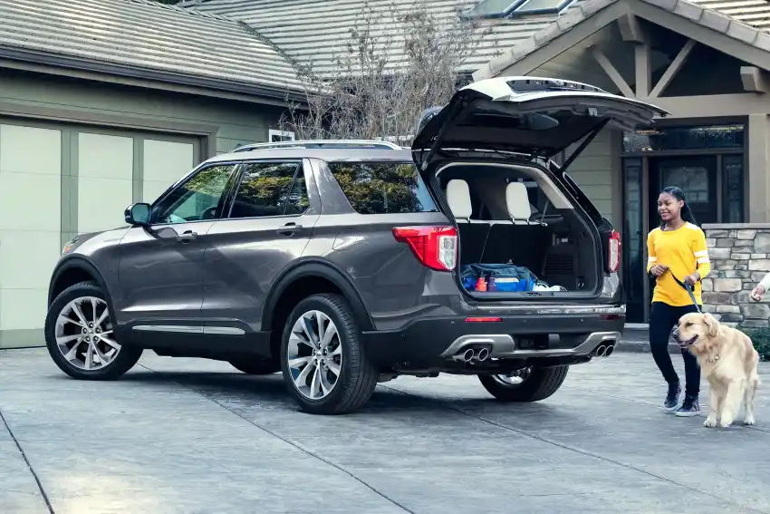 Woman and dog beside a Ford SUV in a driveway