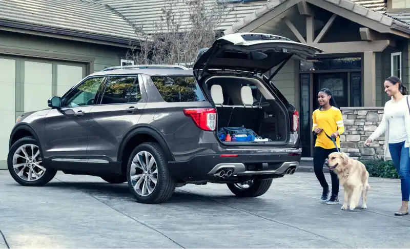 Family loading a Ford Explorer in driveway