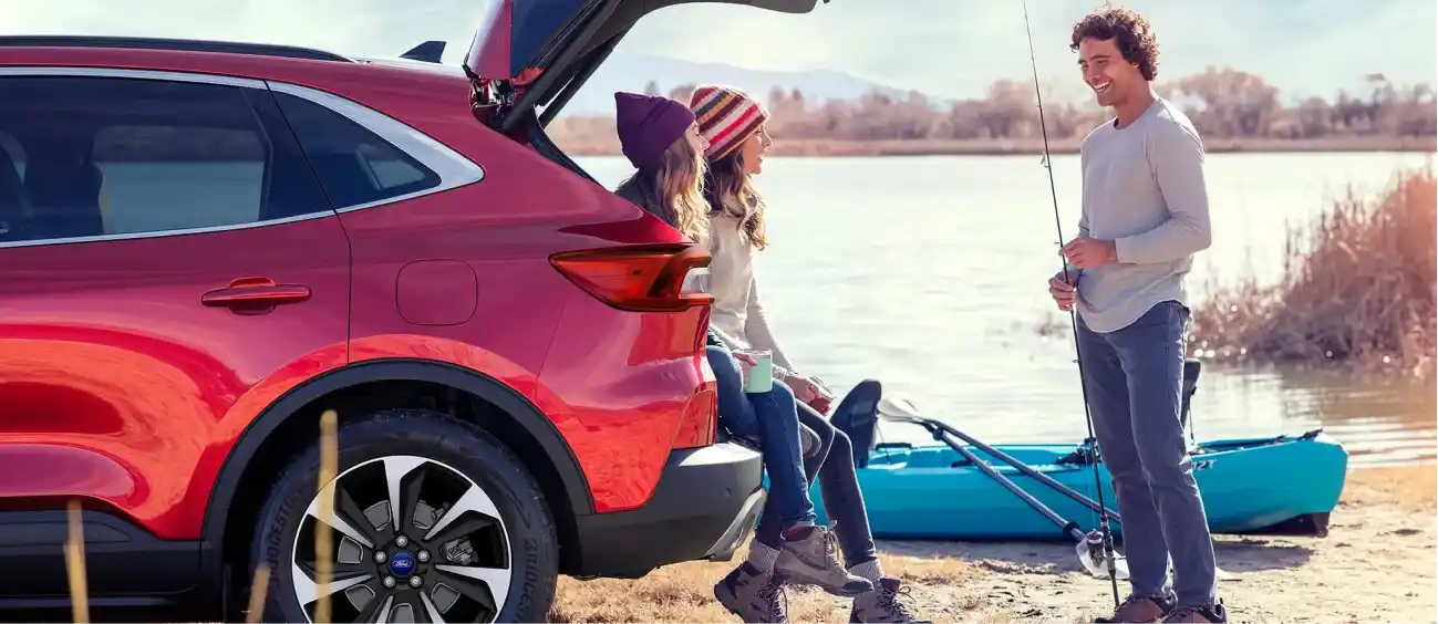 Family with a red Ford Escape at the lake