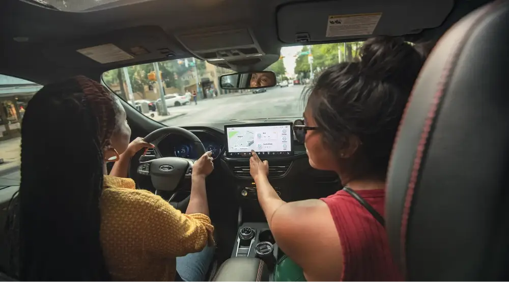 Two women using the touchscreen in a Ford