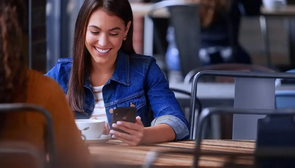 Woman smiling while looking at her phone
