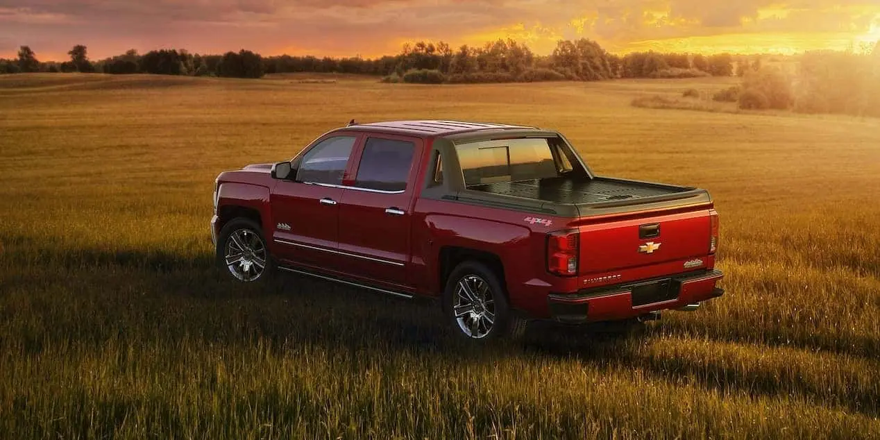 Red Chevy Silverado in Field at Sunset