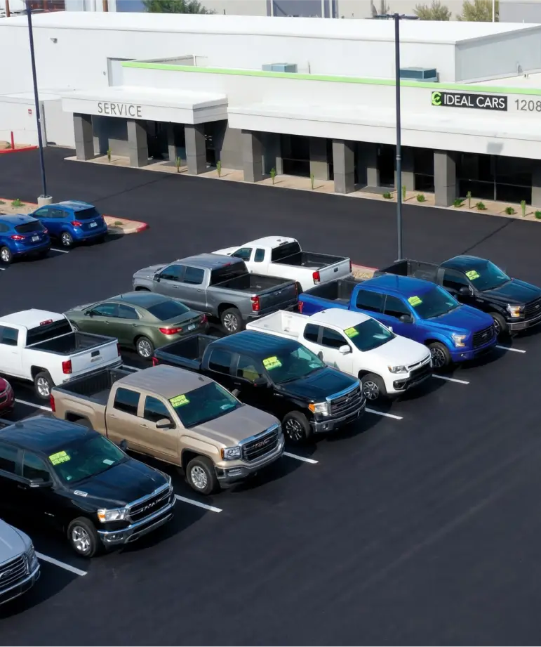 Vehicle inventory displayed outside Ideal Cars dealership.