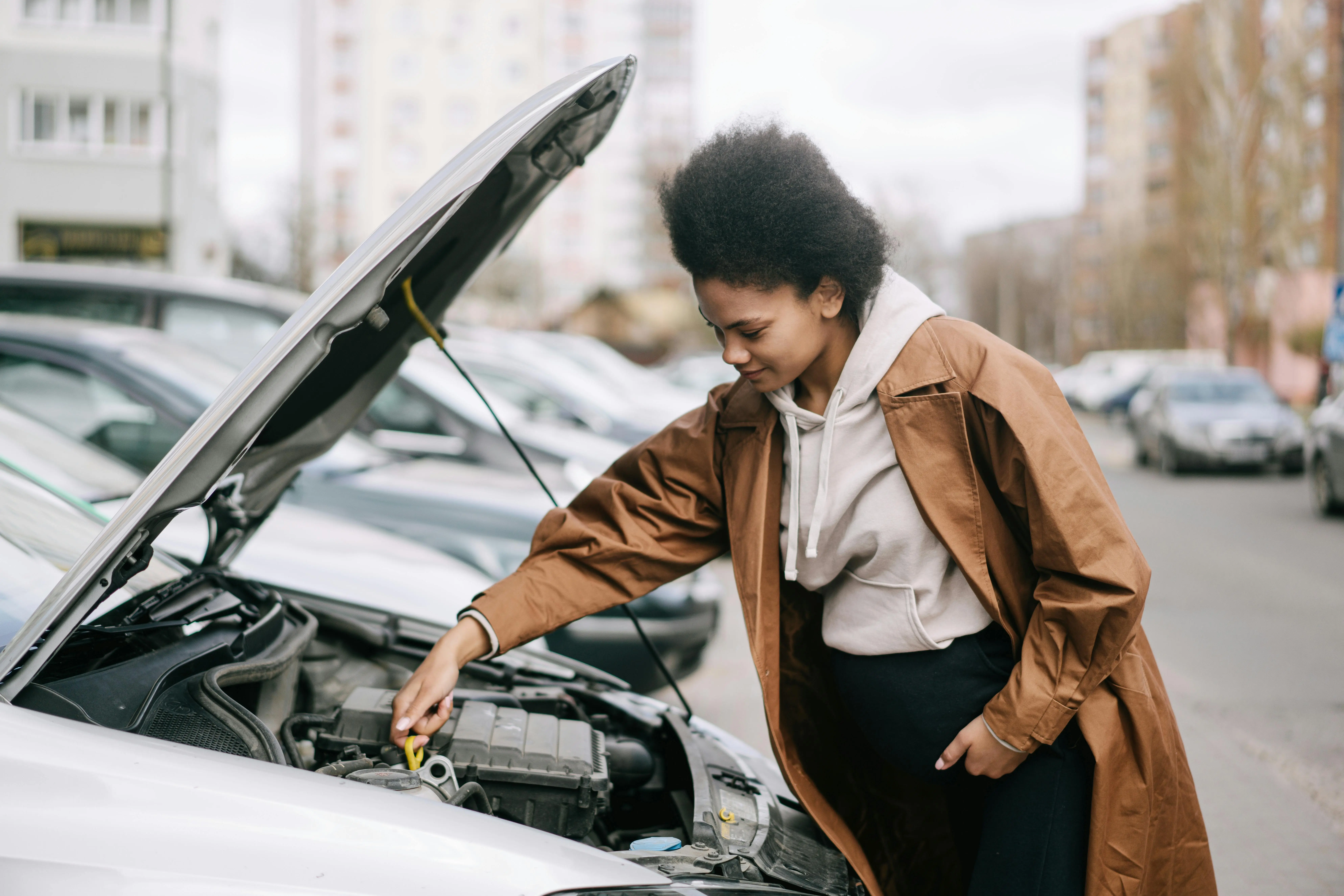 https://www.pexels.com/photo/a-pregnant-woman-fixing-a-car-engine-7990617/
