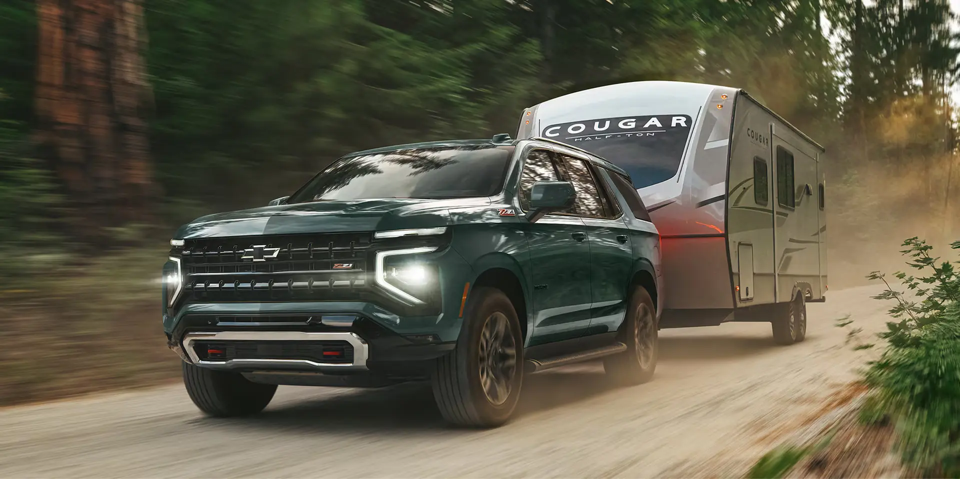 A green suv pulling a trailer off-road.